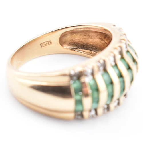 118 - A gold emerald and diamond dome ring. The yellow gold dome ring having nine columns each with three ... 