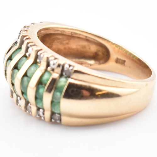 118 - A gold emerald and diamond dome ring. The yellow gold dome ring having nine columns each with three ... 