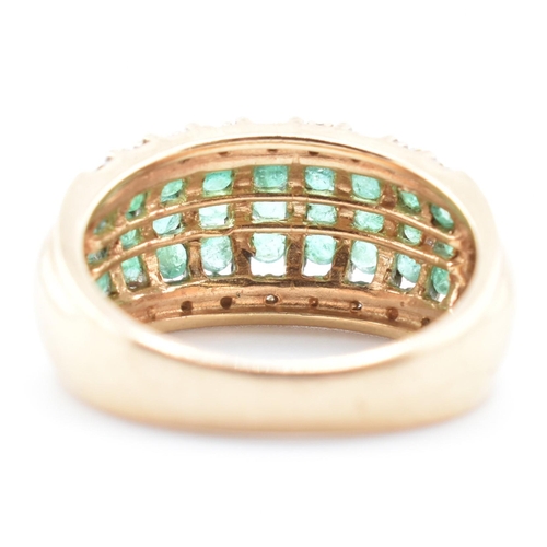 118 - A gold emerald and diamond dome ring. The yellow gold dome ring having nine columns each with three ... 