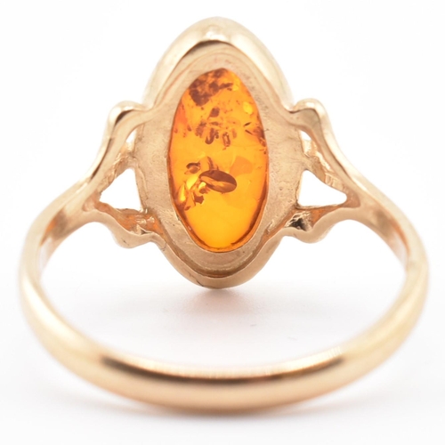 123 - A hallmarked 9ct gold and amber ring. The 9ct yellow gold ring set with a bezel set amber cabochon w... 