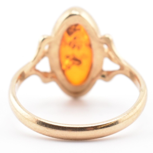 123 - A hallmarked 9ct gold and amber ring. The 9ct yellow gold ring set with a bezel set amber cabochon w... 