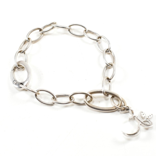 126a - An 18ct white gold oval link chain bracelet strung with an 'E' monogram drop pendant to oval carabin... 