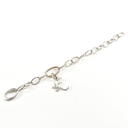 126a - An 18ct white gold oval link chain bracelet strung with an 'E' monogram drop pendant to oval carabin... 