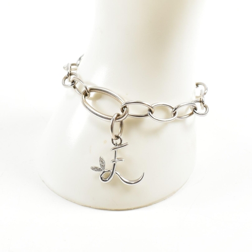 126a - An 18ct white gold oval link chain bracelet strung with an 'E' monogram drop pendant to oval carabin... 