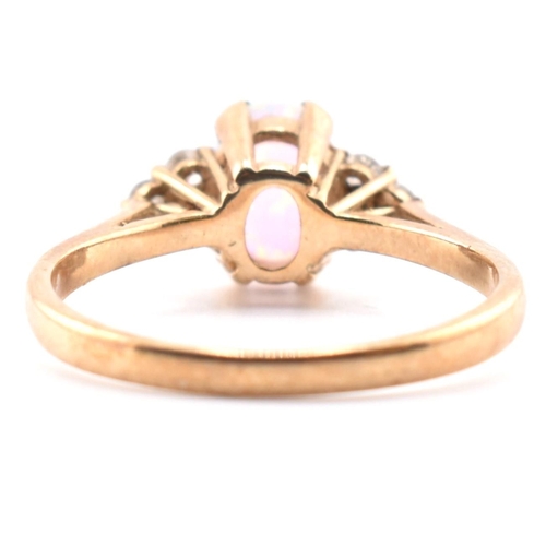 128 - A hallmarked 9ct gold synthetic opal and diamond ring. The 9ct yellow gold ring set with an oval syn... 