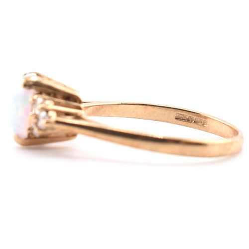 128 - A hallmarked 9ct gold synthetic opal and diamond ring. The 9ct yellow gold ring set with an oval syn... 