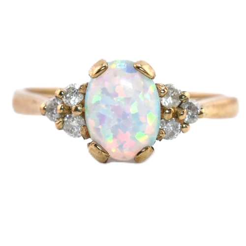 128 - A hallmarked 9ct gold synthetic opal and diamond ring. The 9ct yellow gold ring set with an oval syn... 