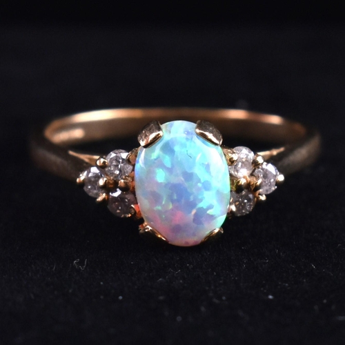 128 - A hallmarked 9ct gold synthetic opal and diamond ring. The 9ct yellow gold ring set with an oval syn... 