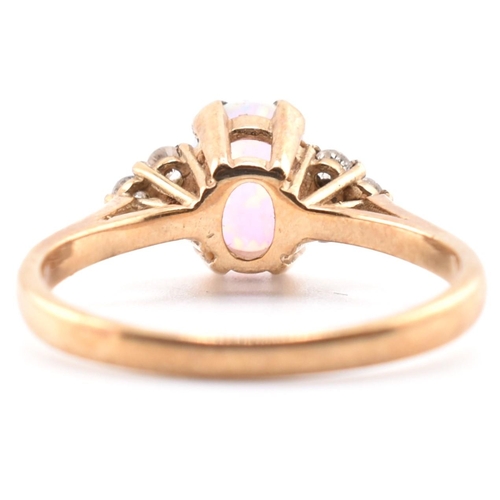 128 - A hallmarked 9ct gold synthetic opal and diamond ring. The 9ct yellow gold ring set with an oval syn... 