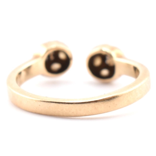 133 - A hallmarked 9ct gold and CZ ball torque ring. The 9ct yellow gold torque ring having two ball finia... 