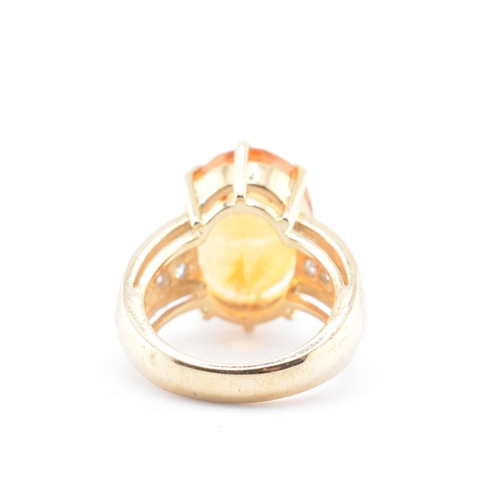 135 - A hallmarked 9ct gold, citrine and diamond ring. The 9ct yellow gold ring set with a central six cla... 