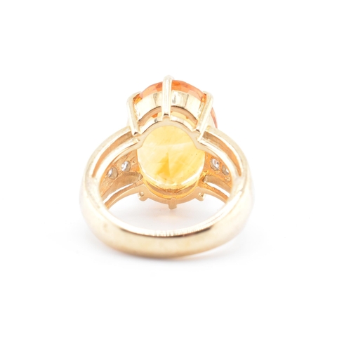 135 - A hallmarked 9ct gold, citrine and diamond ring. The 9ct yellow gold ring set with a central six cla... 