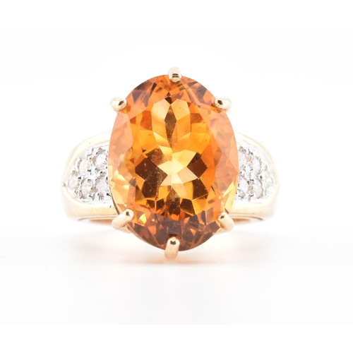 135 - A hallmarked 9ct gold, citrine and diamond ring. The 9ct yellow gold ring set with a central six cla... 