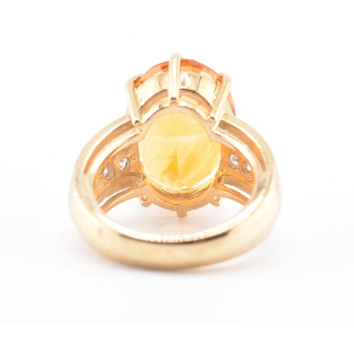 135 - A hallmarked 9ct gold, citrine and diamond ring. The 9ct yellow gold ring set with a central six cla... 