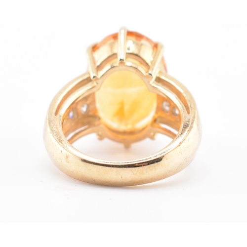 135 - A hallmarked 9ct gold, citrine and diamond ring. The 9ct yellow gold ring set with a central six cla... 