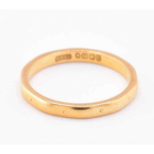 137 - A hallmarked 22ct gold band ring. The 22ct yellow gold band ring having small stamped circles around... 