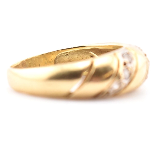 138 - An 18ct gold and CZ dome ring. The 18ct yellow gold dome ring set with three slanted rows of three r... 