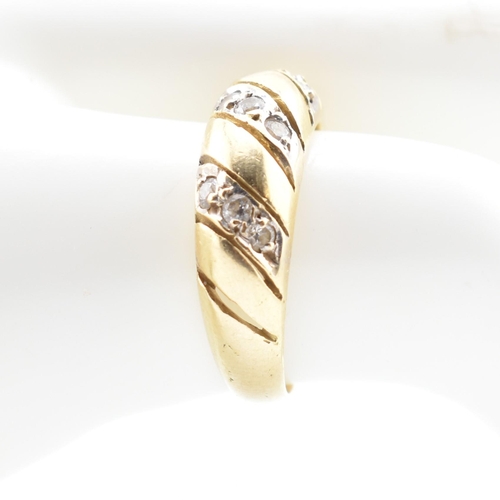 138 - An 18ct gold and CZ dome ring. The 18ct yellow gold dome ring set with three slanted rows of three r... 