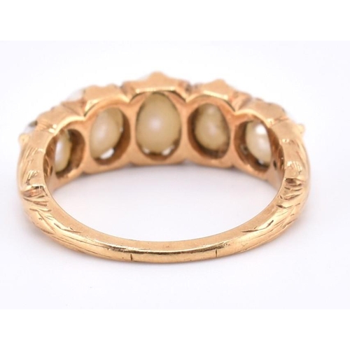 140 - A gold and pearl five stone ring. The gold ring set with five graduating full pearls to decorative s... 