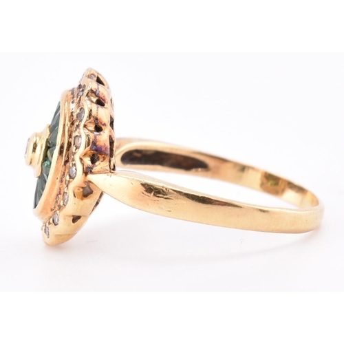 141 - A hallmarked 18ct gold, emerald and diamond ring. The 18ct yellow gold ring having a central bezel s... 