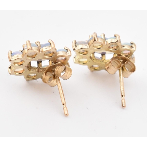 145 - A pair of 9ct gold and opal cluster stud earrings. The 9ct yellow gold earrings having a central cla... 