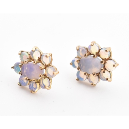 145 - A pair of 9ct gold and opal cluster stud earrings. The 9ct yellow gold earrings having a central cla... 