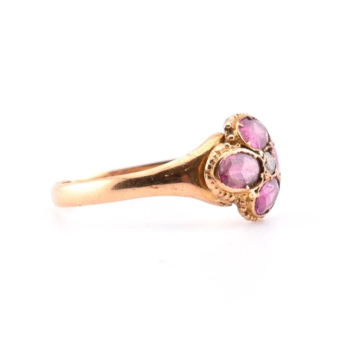 15 - A Victorian hallmarked 15ct gold, garnet and diamond flower ring. The Victorian gold ring having a r... 