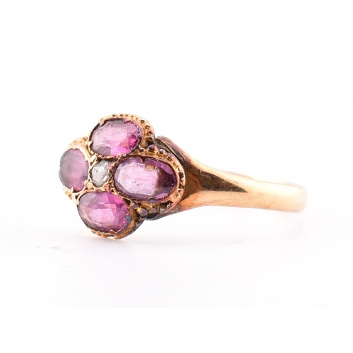 15 - A Victorian hallmarked 15ct gold, garnet and diamond flower ring. The Victorian gold ring having a r... 