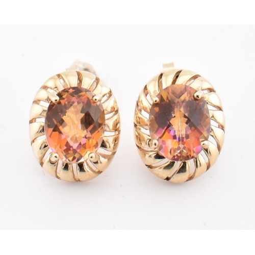 150 - A pair of hallmarked 9ct gold and mystic topaz stud earrings. The hallmarked 9ct yellow gold stud ea... 