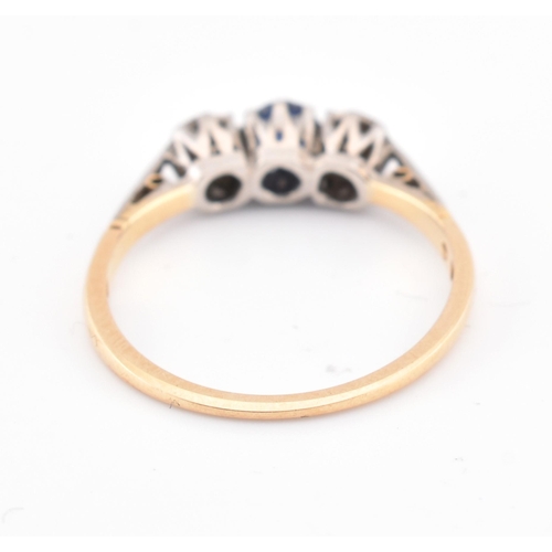 156 - An 18ct gold and platinum sapphire and diamond three stone ring. The ring set with a central round c... 