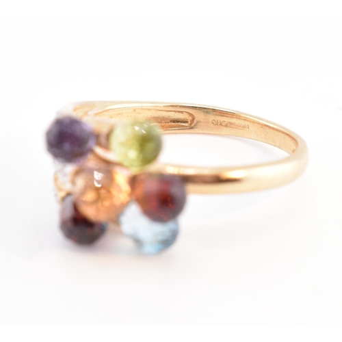 158 - A hallmarked 9ct gold multi-stone crossover ring. The 9ct yellow gold ring having faceted garnet, am... 