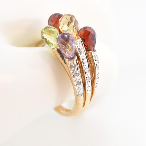 158 - A hallmarked 9ct gold multi-stone crossover ring. The 9ct yellow gold ring having faceted garnet, am... 