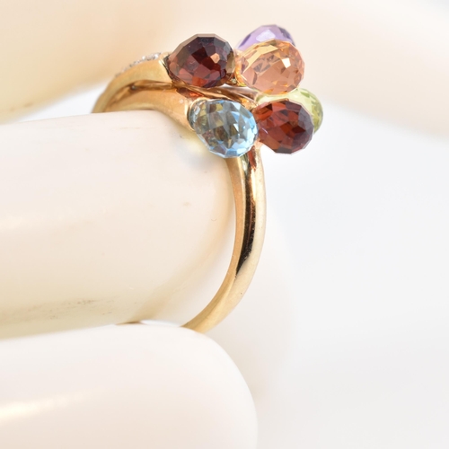 158 - A hallmarked 9ct gold multi-stone crossover ring. The 9ct yellow gold ring having faceted garnet, am... 