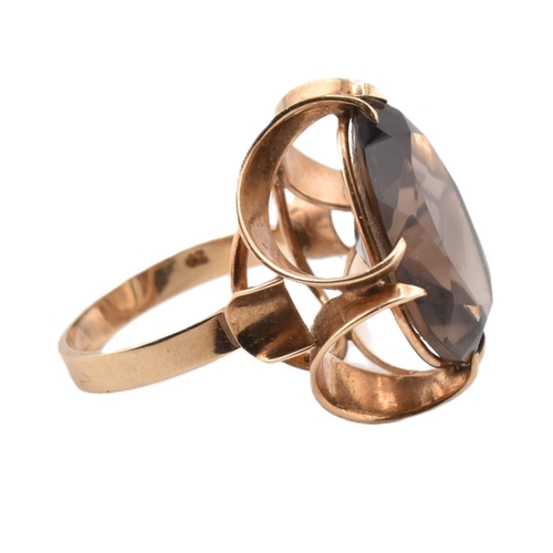 163 - A 1970s hallmarked 9ct gold and smoky quartz cocktail ring. The ring set with a single oval cut smok... 