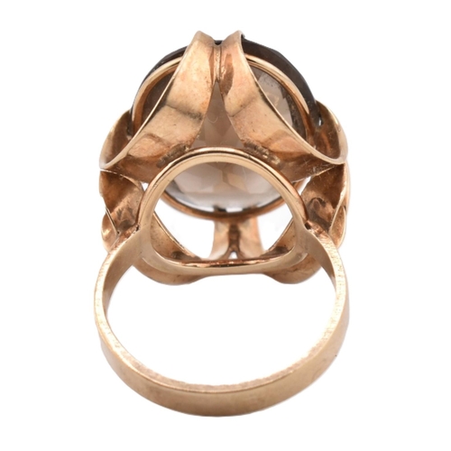 163 - A 1970s hallmarked 9ct gold and smoky quartz cocktail ring. The ring set with a single oval cut smok... 