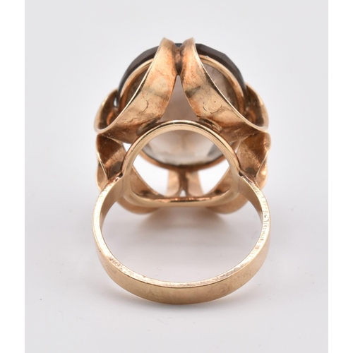 163 - A 1970s hallmarked 9ct gold and smoky quartz cocktail ring. The ring set with a single oval cut smok... 