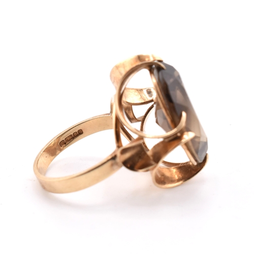 163 - A 1970s hallmarked 9ct gold and smoky quartz cocktail ring. The ring set with a single oval cut smok... 