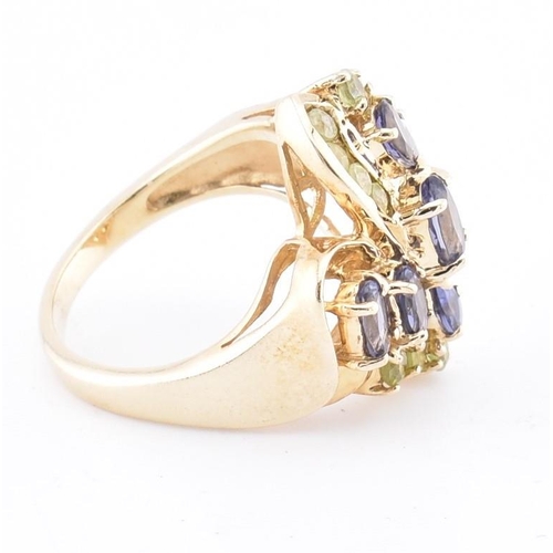 168 - A hallmarked 9ct gold peridot and iolite cluster ring. The 9ct yellow gold ring set with four oval c... 