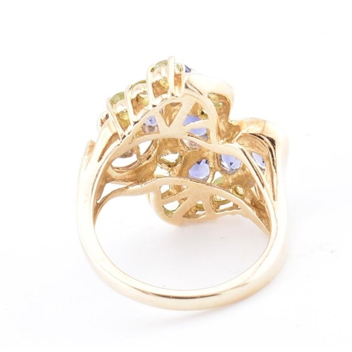 168 - A hallmarked 9ct gold peridot and iolite cluster ring. The 9ct yellow gold ring set with four oval c... 