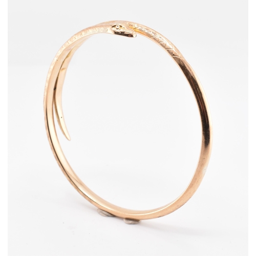 17 - A 19th-century hallmarked 9ct gold snake bangle. The bangle with textured and etched body. Hallmarke... 