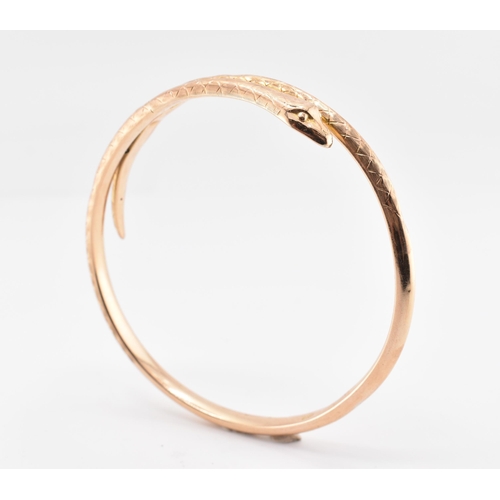 17 - A 19th-century hallmarked 9ct gold snake bangle. The bangle with textured and etched body. Hallmarke... 