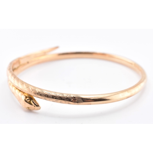 17 - A 19th-century hallmarked 9ct gold snake bangle. The bangle with textured and etched body. Hallmarke... 