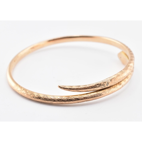 17 - A 19th-century hallmarked 9ct gold snake bangle. The bangle with textured and etched body. Hallmarke... 