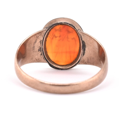 171 - A 19th century gold intaglio ring. The ring having an oval carnelian intaglio depicting two warriors... 