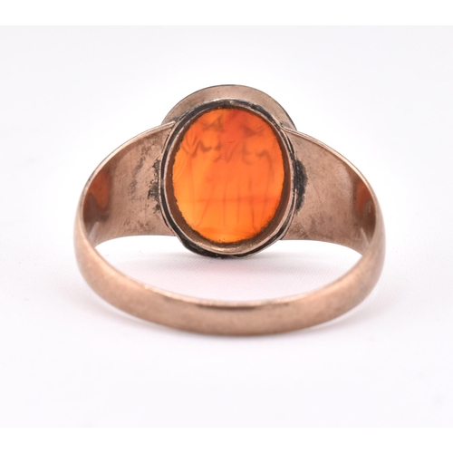 171 - A 19th century gold intaglio ring. The ring having an oval carnelian intaglio depicting two warriors... 