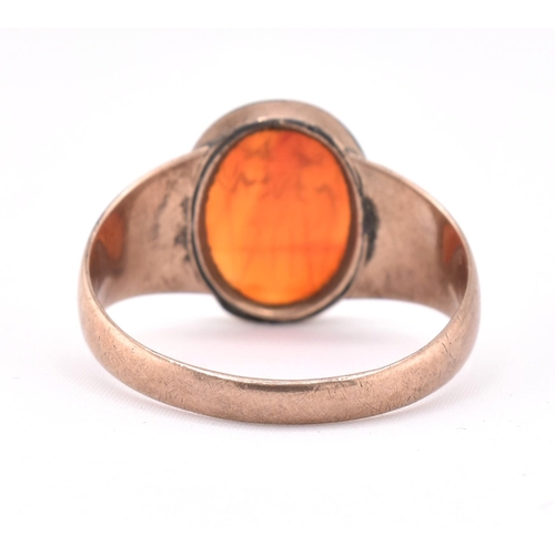 171 - A 19th century gold intaglio ring. The ring having an oval carnelian intaglio depicting two warriors... 