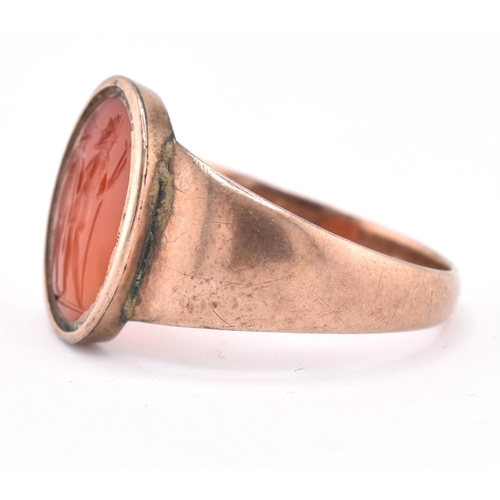 171 - A 19th century gold intaglio ring. The ring having an oval carnelian intaglio depicting two warriors... 