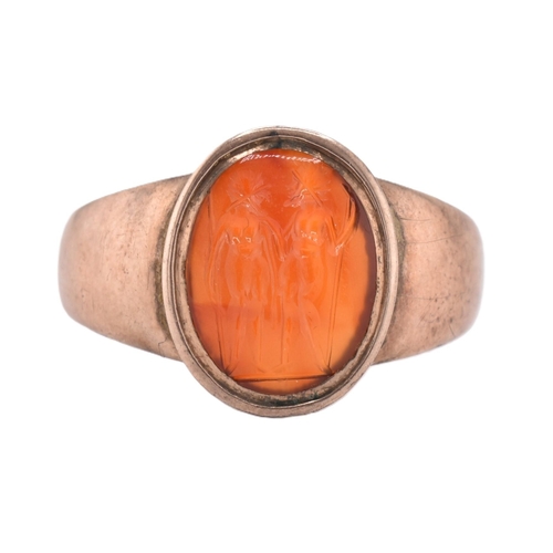 171 - A 19th century gold intaglio ring. The ring having an oval carnelian intaglio depicting two warriors... 