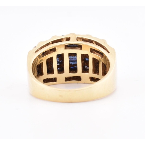 172 - A 14ct gold blue and white sapphire dome ring. The yellow gold ring five rows of calibre blue sapphi... 