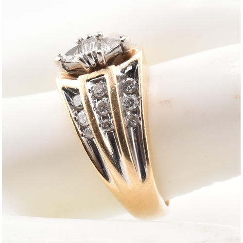 177 - A gold and diamond fancy cluster ring. The yellow gold ring set with a central east-west baguette cu... 